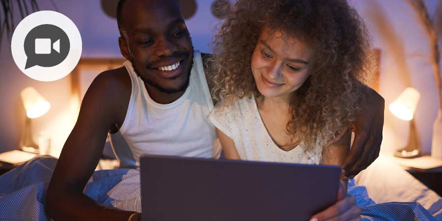 Young couple in bed using video chat.